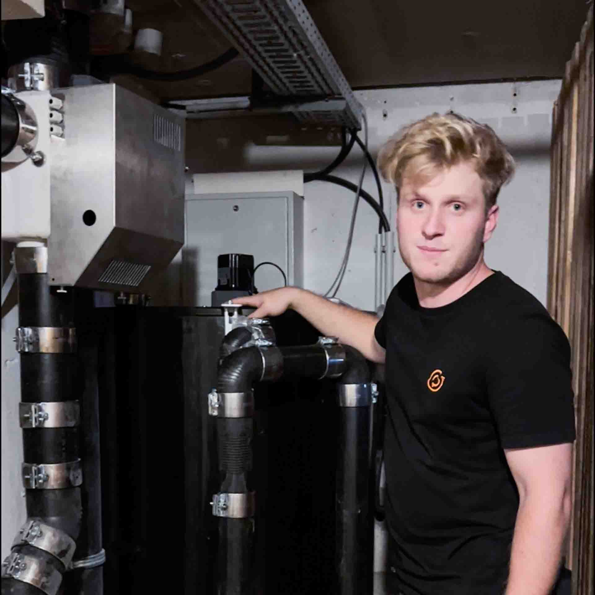 Felix Drechsel next to a sewage heat exchanger in Stadtroda